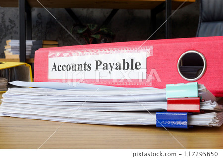 Stack of papers and folder labeled accounts payable. Financial management and accounting tasks. Stack of papers and folder labeled accounts payable. Financial management and accounting tasks. 117295650