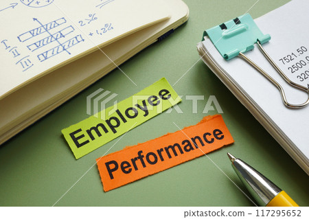 Employee performance written on pieces of paper on an office desk. Employee performance written on pieces of paper on an office desk. 117295652