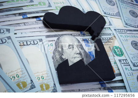 Close-up of a model of a smoking factory and money. Economic issues and environmental impact. Close-up of a model of a smoking factory and money. Economic issues and environmental impact. 117295656