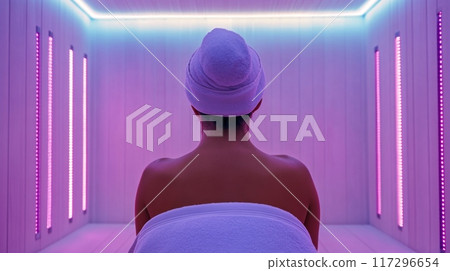 Woman Relaxing in Modern LED Light Sauna Room 117296654