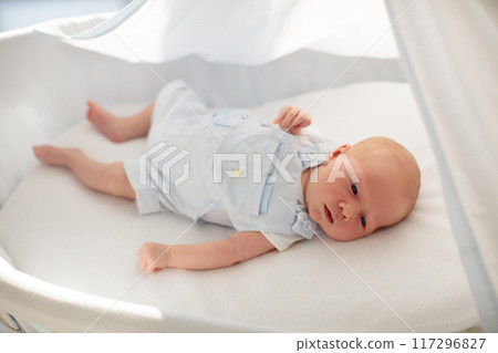 Little baby on white bed 117296827