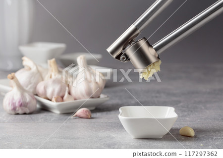 Squeeze the garlic with a garlic press. 117297362