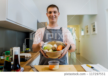 Chef at the kitchen preparing healthy quinoa bowl with avocado 117297551