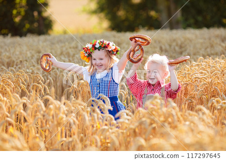 Child in wheat field with German bread Child in wheat field with German bread 117297645
