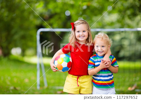 Child playing football. Kids play soccer. Child playing football. Kids play soccer. 117297652