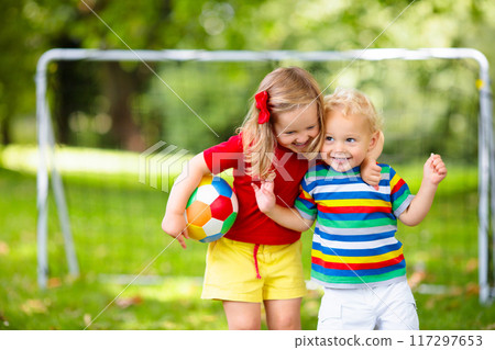 Child playing football. Kids play soccer. 117297653