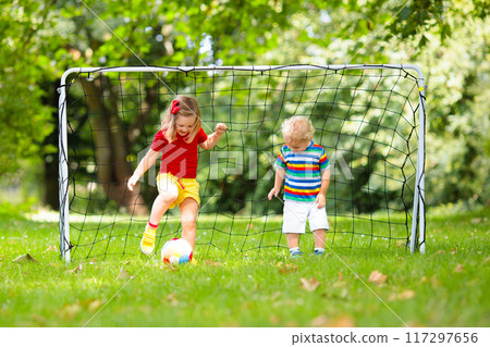 Child playing football. Kids play soccer. Child playing football. Kids play soccer. 117297656