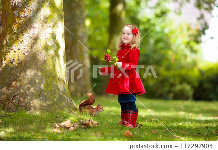 Child in fall park. Kid with autumn leaves. 117297903