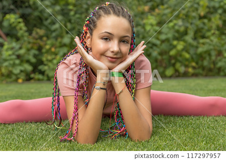 Flexible young girl does the spits and rests her head in her hands. Flexible young girl does the spits and rests her head in her hands. 117297957