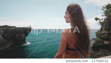 Young woman is standing on a cliff overlooking the ocean at weekurri lagoon salt lake, enjoying the peace and beauty of nature 117298152