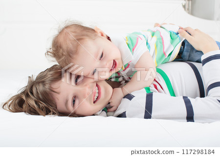 Kids playing on parents bed Kids playing on parents bed 117298184