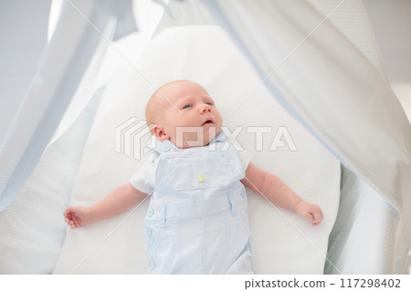 Little baby on white bed 117298402