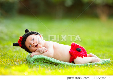 Baby in cute dress up costume. Newborn in garden. 117298408