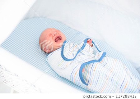 Swaddling newborn child. Baby in swaddle blanket. Swaddling newborn child. Baby in swaddle blanket. 117298412