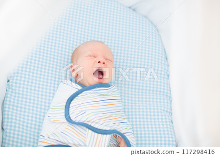Swaddling newborn child. Baby in swaddle blanket. Swaddling newborn child. Baby in swaddle blanket. 117298416