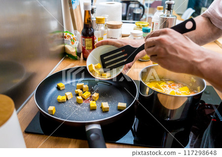 Chef at the kitchen preparing pumpkin porridge with tofu and vegetables 117298648