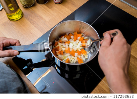 Chef at the kitchen preparing pumpkin porridge with tofu and vegetables 117298658