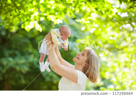 Mother holding newborn baby in a park Mother holding newborn baby in a park 117298984