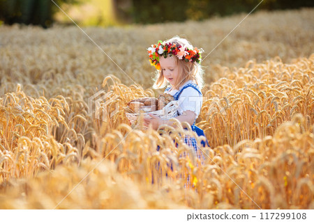 Child in wheat field with German bread Child in wheat field with German bread 117299108