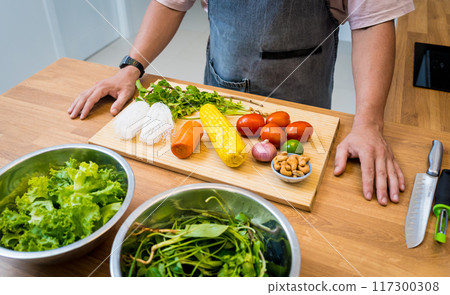 Chef at the kitchen preparing spicy glass noodle salad 117300308