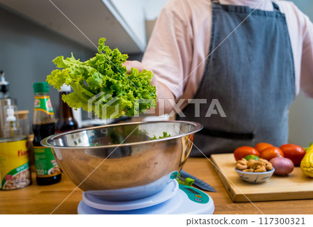 Chef at the kitchen preparing spicy glass noodle salad 117300321