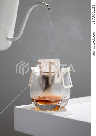 Drip bag brews coffee meticulously. 117301121