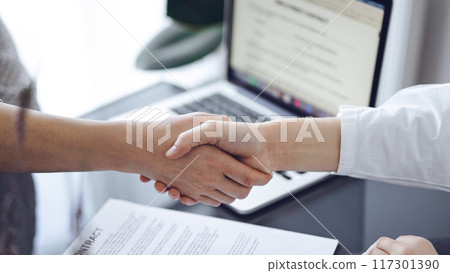Business people shaking hands above contract papers just signed on the grey table, close up. Lawyers or entrepreneurs at meeting. Teamwork, success concept 117301390