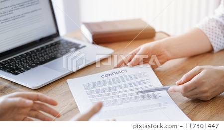Businesswoman lawyer pointing into contract special points admitting something for colleague or client at the wooden desk in office. Business people teamwork and partnership, meeting concept Businesswoman lawyer pointing into contract special points admitting something for colleague or client at the wooden desk in office. Business people teamwork and partnership, meeting concept 117301447