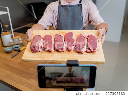 Raw fillet beef meat for steaks on the home electric grill Raw fillet beef meat for steaks on the home electric grill 117302183