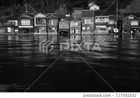 Morning monochrome of boathouses reflected on the water 117302832