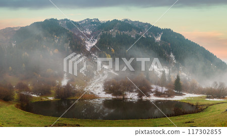 Autumn landscape with a reflective lake and light snow in rural Artvin, Turkey. Vast autumn scenery with vibrant seasonal colors in the Eastern Anatolia, Black Sea region 117302855