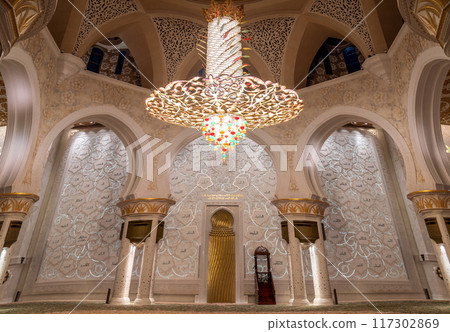 Stunning golden chandelier inside the Sheikh Zayed Grand Mosque in Abu Dhabi, showcasing exquisite Islamic architecture. 117302869