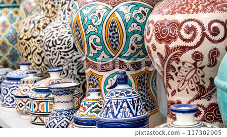 Colorful Moroccan pottery and ceramics displayed outside shops in the souks, showcasing traditional designs and craftsmanship. Colorful Moroccan pottery and ceramics displayed outside shops in the souks, showcasing traditional designs and craftsmanship. 117302905