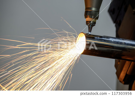 Close up scene the fiber laser cutting machine cut the stainless steel tube and sparkling light. 117303956