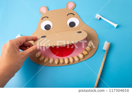 DIY, recycling craft concept, teeth and dental health for kids education, a paper cut shaped like a hippo with a toothbrush, 117304658