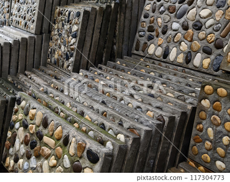 A pile of concrete tiles filled with rocks on top 117304773