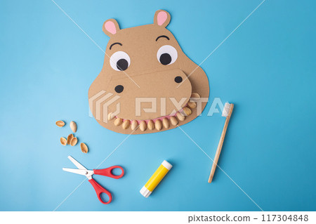Hands-on DIY craft image illustrating a recycling concept for kids' dental education, depicting a paper cutout designed as a hippo with a toothbrush, emphasizing dental hygiene Hands-on DIY craft image illustrating a recycling concept for kids' dental education, depicting a paper cutout designed as a hippo with a toothbrush, emphasizing dental hygiene 117304848
