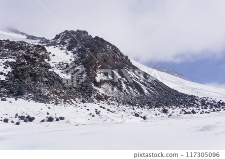 highland mountain landscape, snow-capped basalt rocks on the slope of Elbrus, 5000 meters above sea level 117305096