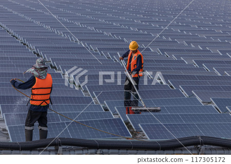 Worker Cleaning floating solar panels or solar cell Platform system on the lake with brush and water Worker Cleaning floating solar panels or solar cell Platform system on the lake with brush and water 117305172