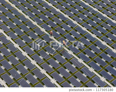 Worker Cleaning floating solar panels or solar cell Platform system on the lake with brush and water Worker Cleaning floating solar panels or solar cell Platform system on the lake with brush and water 117305180