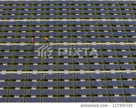 Worker Cleaning floating solar panels or solar cell Platform system on the lake with brush and water Worker Cleaning floating solar panels or solar cell Platform system on the lake with brush and water 117305183