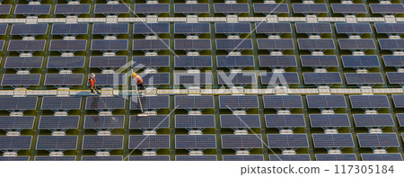 Worker Cleaning floating solar panels or solar cell Platform system on the lake with brush and water 117305184