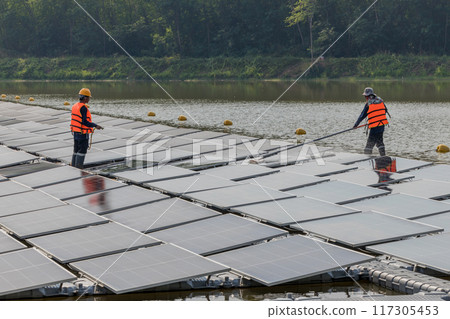 Worker Cleaning floating solar panels Worker Cleaning floating solar panels 117305453