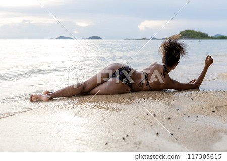 Beautiful girl on sun tanning in a tropical beach Beautiful girl on sun tanning in a tropical beach 117305615