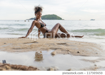 Beautiful girl on sun tanning in a tropical beach Beautiful girl on sun tanning in a tropical beach 117305650