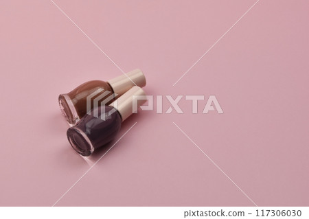 Nail polish small glass bottles on pink background, professional manicure concept 117306030