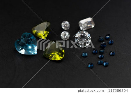 Colorful faceted gemstones on black background 117306204