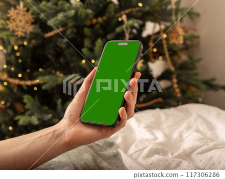 Lodz Poland July 20 2024 Hand holding mobile phone mockup, iphone screen mock up, Christmas holiday Lodz Poland July 20 2024 Hand holding mobile phone mockup, iphone screen mock up, Christmas holiday 117306286