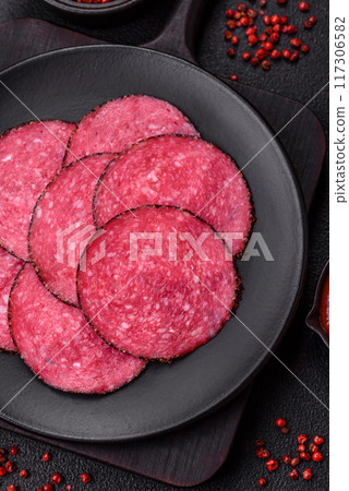 Delicious smoked salami sausage sliced with salt, spices and herbs Delicious smoked salami sausage sliced with salt, spices and herbs 117306582