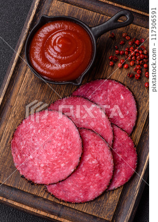 Delicious smoked salami sausage sliced with salt, spices and herbs 117306591